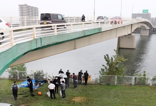 遺体が見つかった神崎川の現場付近を再び捜索する兵庫県警の捜査員＝５日午後２時３５分、尼崎市戸ノ内町