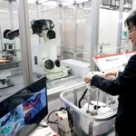 手元のハンドルで回転砥石を操作し、鉄板を研磨する遠隔ロボット。砥石の動きはモニターでチェックできる＝東京都江東区有明３