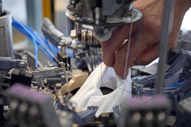 マスクの製造シーン。靴下と同様に、筒状に編み込んでいく＝尼崎市西川２