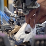 マスクの製造シーン。靴下と同様に、筒状に編み込んでいく＝尼崎市西川２