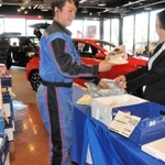生協の商品の受け渡しに当たる作業着姿のスタッフ＝神戸市西区糀台５、ネッツトヨタ兵庫西神中央店