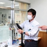事務室の窓口に抗ウイルスランプを設置するウシオ電機の担当者ら＝たつの市新宮町芝田、兵庫県立龍野北高校