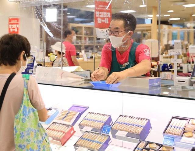 閉店が迫る中、笑顔で接客するそごう西神店の三原浩文さん＝７月３０日、神戸市西区糀台５（撮影・鈴木雅之）