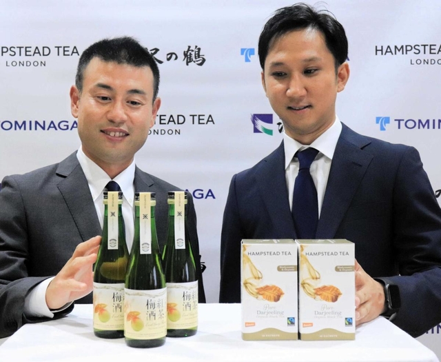 共同開発した梅酒と、使った紅茶を紹介する沢の鶴の西村隆社長（左）と富永貿易の富永昌平社長＝神戸市中央区北野町４