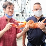 過去最高の１匹３０万円で香住ガニを競り落とした海産物販売業者と井岡弘樹さん（左）＝６日午前、香住漁港西港