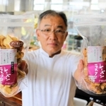 新商品「ことぶきのぶどうぱん　レーズンラスク」を手にする増成豊美さん＝ベーカリーカフェコトブキ