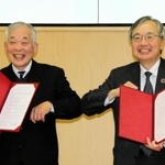 協定書を手に肘タッチをする兵庫工業会の宮脇新也会長（右）と武庫川女子大の瀬口和義学長＝西宮市池開町、武庫川女子大