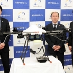 消毒に使うドローンを囲むミラテクドローンの佐々木康之社長（左）ら＝神戸市中央区港島中町６