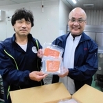 純神戸産のスモークサーモンを手にする「すまうら水産」の森本明代表（左）と「オーシャンベスト」の門田和士社長＝神戸市兵庫区