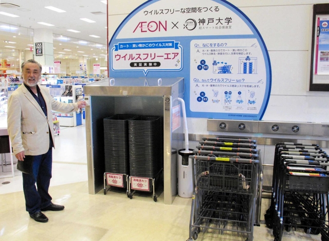 買い物かごやカート向けの除菌・抗ウイルス装置を前にする神戸大の長廣剛特命教授＝神戸市北区上津台８、イオン神戸北店