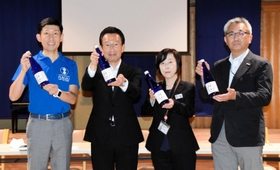 完成した純米吟醸酒「環和」を掲げる神戸酒心館の安福武之助社長（左端）ら＝神戸市東灘区御影塚町１