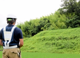 資源循環型の肥料で育てる山田錦の田んぼをドローンで撮影するスタッフ＝２０２０年７月、神戸市北区