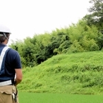 資源循環型の肥料で育てる山田錦の田んぼをドローンで撮影するスタッフ＝２０２０年７月、神戸市北区