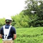 資源循環型の肥料で育てる山田錦の田んぼをドローンで撮影するスタッフ＝２０２０年７月、神戸市北区