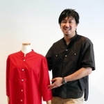 「ＹＯＵＫＡ（ヨウカ）」のブラウスを手にするトリニティの添田優作社長＝西宮市津門大箇町