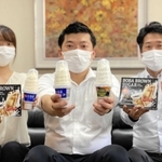 輸出用に生産しているソフトクリームを手にする田口翔一副社長（中央）ら＝田口食品