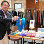 完成した靴下を手にする田中繊維の田中一成常務＝大阪市北区梅田３、ルクア　イーレ