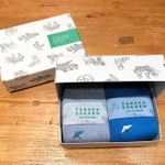 包装箱には、工場で働く人や編み機の部品をデザインした＝大阪市北区梅田３