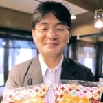 炭酸煎餅を使った「ザクッとチョコのスフレサンド」を手にする三ツ森の弓削次郎常務＝神戸市北区有馬町