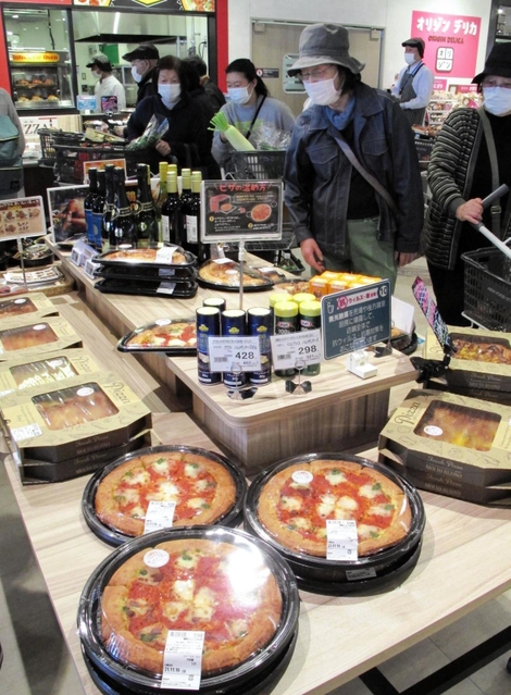 温かいピザも売りの一つ。奥の調理場から、焼きたてを店頭に並べる＝神戸市西区玉津町小山