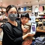 Ｆ・Ｏ・インターナショナルのバーチャル試着サービスを利用する親子＝神戸市中央区三宮町２、ＢＲＥＥＺＥ神戸三宮本店