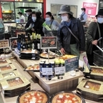 温かいピザも売りの一つ。奥の調理場から、焼きたてを店頭に並べる＝神戸市西区玉津町小山