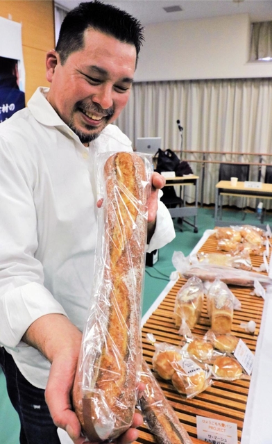 もち麦を使ったバゲットを手にするサ・マーシュの西川功晃シェフ