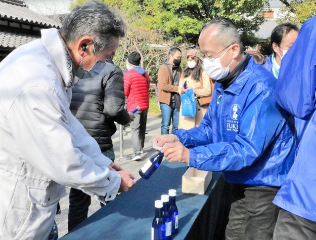 「福寿」を受け取る来場者（左）＝神戸市東灘区御影塚町１、神戸酒心館