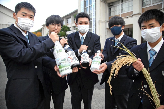 日本酒「東雲の穂」と、原料の酒米を育てた篠山東雲高校アグリプロダクト類型の生徒たち＝丹波篠山市福住、篠山東雲高校