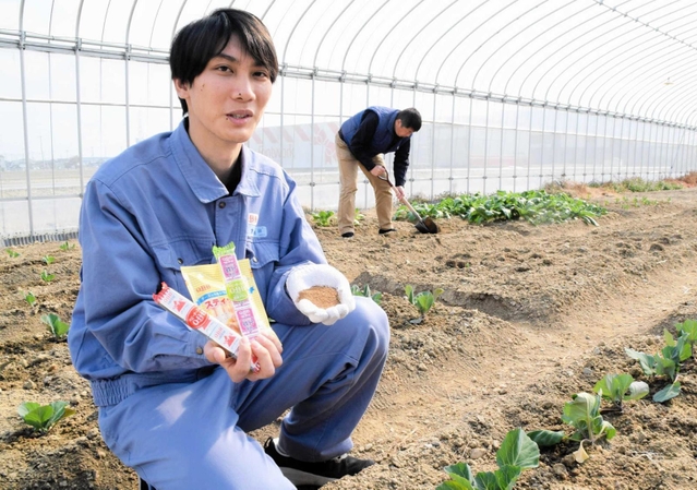 規格外のチーズを配合した肥料で野菜を育てる六甲バターの安木亮佑さん（左）＝兵庫県稲美町岡