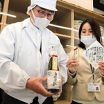 日本酒を手にする田中酒造場の田中康博社長（左）ら＝ＪＲ姫路駅