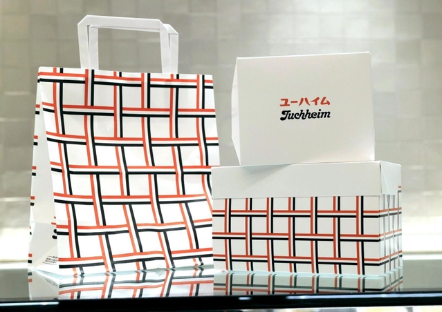 日本での開業１００年を記念して考案した柄「ユーハイムチェック」をあしらった袋や箱＝４日午後、神戸市中央区元町通１（撮影・鈴木雅之）