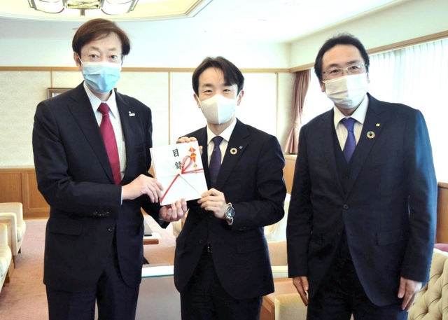 久元市長（左）に目録を手渡す信金中金の小平支店長（中央）と神戸信金の高浜克己常務理事＝神戸市役所