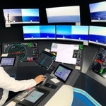 海上の船を遠隔操船できる制御室。船上の周囲を映すカメラ画像や計器のデータを表示するモニターが並ぶ＝千葉市内（日本財団提供）