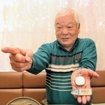 ゆかりの品を手に、新幹線運転士当時の指さし確認をする元国鉄マンの山本光明さん＝明石市別所町