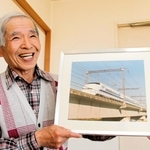 川崎重工業で新幹線車両の塗装を担当し、自ら撮影した新幹線３００系の写真を持つ三浦喜太郎さん＝加古川市平岡町土山