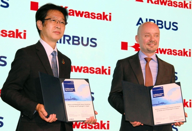 調印式後、撮影に応じる川崎重工業の西村元彦執行役員（左）とエアバス・ジャパンのステファン・ジヌー社長＝１２日午前、東京都港区
