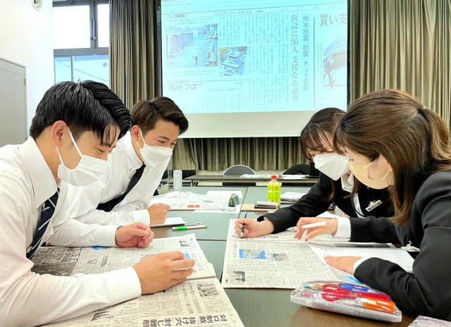 新聞記事を読み込み、業界の課題や解決策を話し合う新入社員ら＝神戸市中央区栄町通４