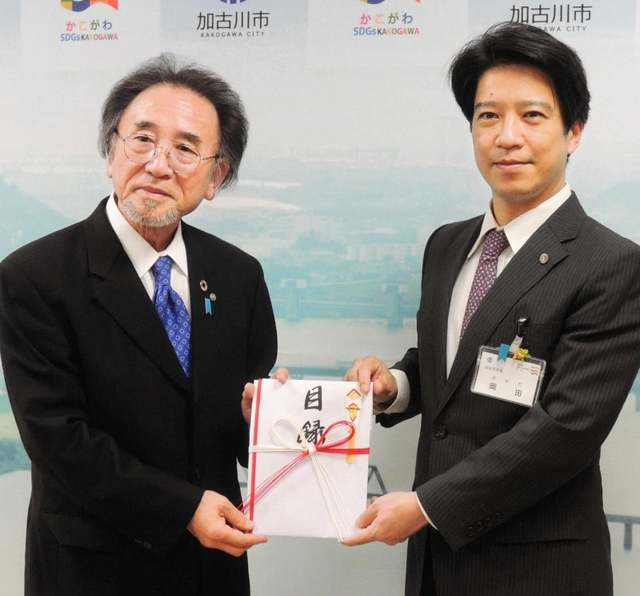 但陽信金の桑田純一郎理事長（左）から１千万円の寄付の目録を受け取る加古川市の岡田康裕市長＝加古川市役所