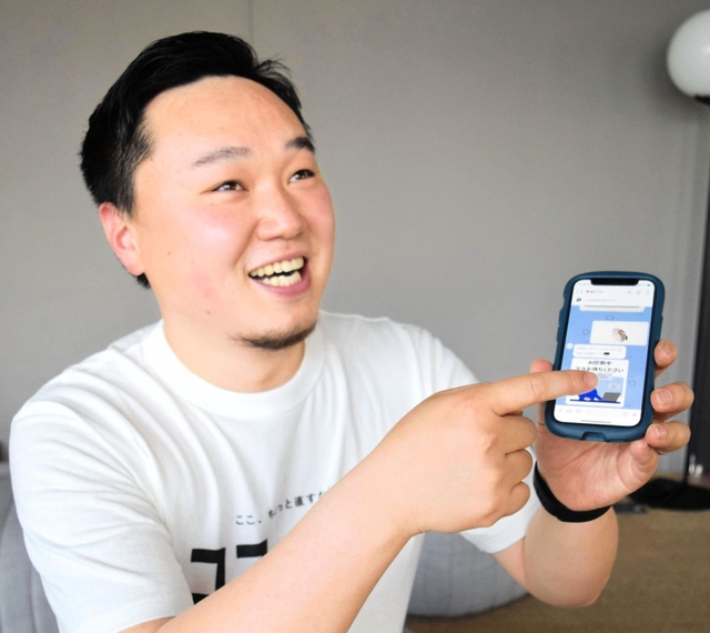 壁に開けた穴の写真をスマートフォンで送る手順を説明する杉田暁さん＝神戸市中央区加納町４、アンカー神戸