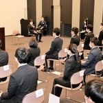 新入社員らに訓示する植野富夫新社長（左奥）＝１日午前、神戸市中央区港島南町４、バンドー化学