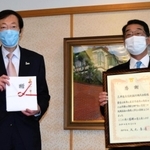 目録を受け取った久元喜造市長（左）と感謝状を手にする田中尚宏専務執行役員＝神戸市役所