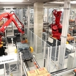 コカ・コーラのボトルが入ったケースをパレットに積み上げるアームロボット＝明石市大久保町西脇（撮影・辰巳直之）