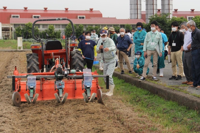 栽培講習会で、省力化に向けた機械での種まき作業を見学する生産者ら＝１日、加西市別府町、兵庫県立農林水産技術総合センター