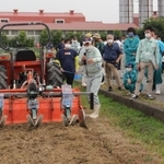 栽培講習会で、省力化に向けた機械での種まき作業を見学する生産者ら＝１日、加西市別府町、兵庫県立農林水産技術総合センター