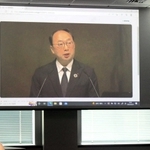 三菱電機の株主総会で発言する漆間啓社長を映す画面＝２９日午前、東京都千代田区（撮影・末永陽子）
