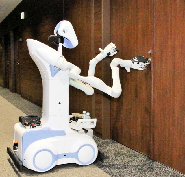 会議室のドアをノックしながら開ける「ニョッキー」＝明石市川崎町