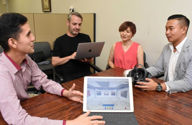 タブレットやＶＲゴーグルを手に、メタバース事業について話すシマフジＩＥＭの島藤真澄ＣＥＯ（左から３人目）ら。海外出身のエンジニアも活躍している＝神戸市中央区港島中町６