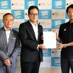 斎藤元彦知事（右）から認定書を受け取った日の出医療福祉グループの大西壯司代表（中央）＝兵庫県庁