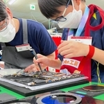 ノートパソコン「レッツノート」を組み立てる参加者（右）と指導役の従業員＝神戸市西区高塚台１